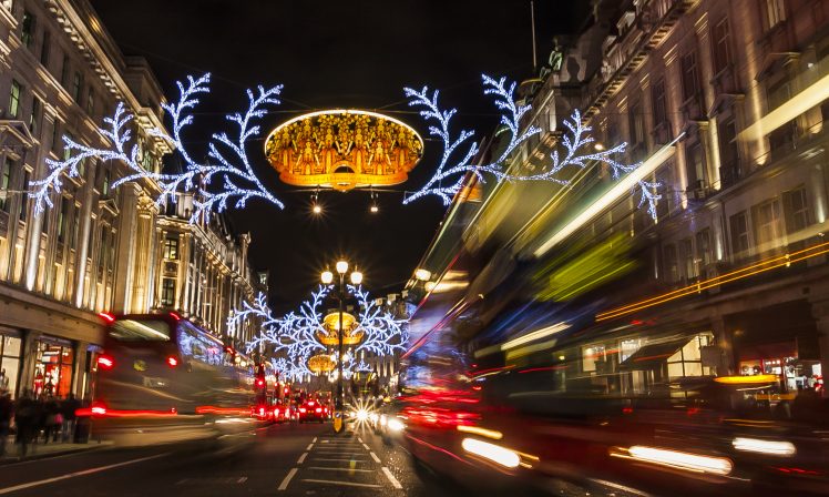Christmas street courier drive below Christmas lights