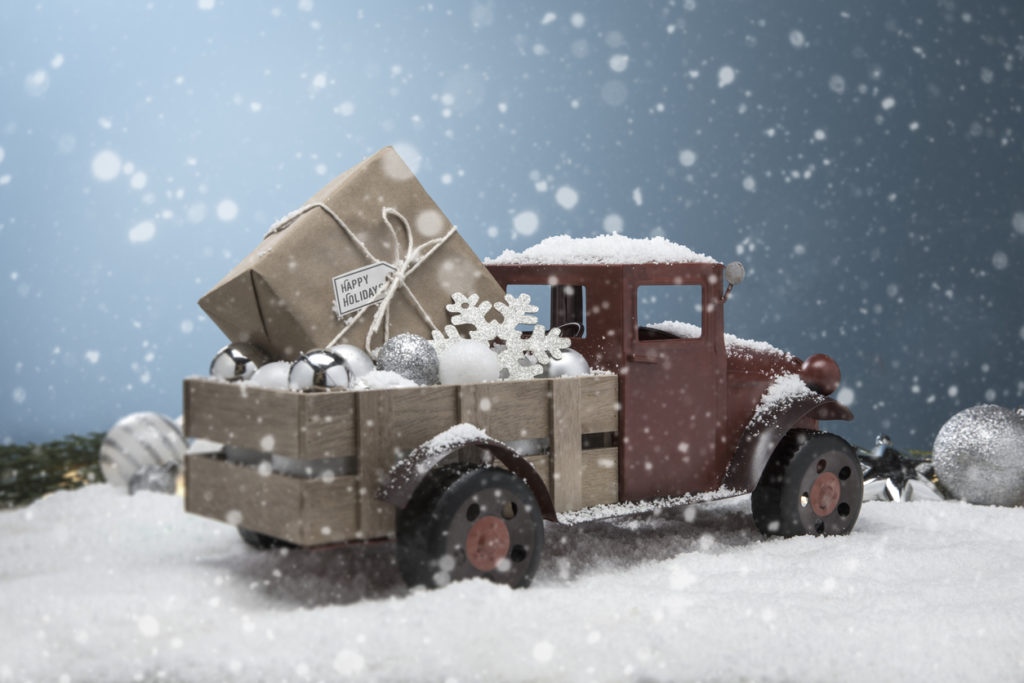 Antique Red pickup Truck in the snow with gift in the back
